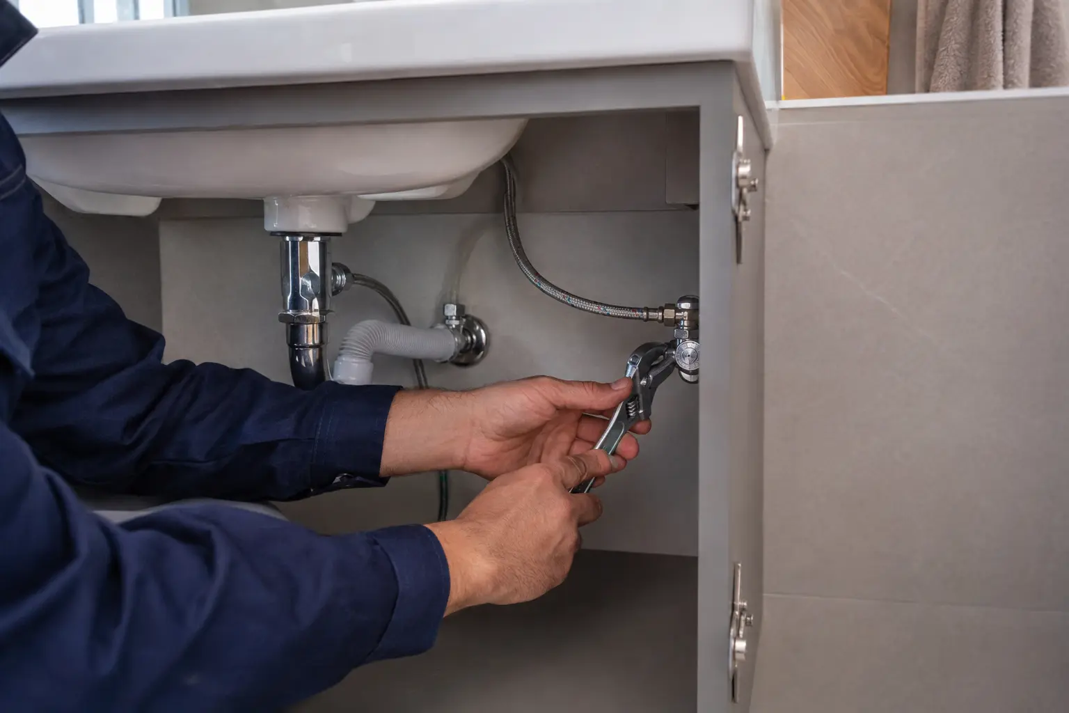 Lavabo altındaki sıhhi tesisat bağlantısını onaran tesisat ustası